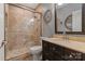 Elegant bathroom featuring a tiled shower, vanity with sink, and decorative mirror at 3196 Stonemill Path, Sherrills Ford, NC 28673