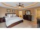 A beautifully styled bedroom boasts tray ceilings, a ceiling fan, and a large wood dresser with mirror at 3196 Stonemill Path, Sherrills Ford, NC 28673