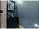 The powder room features a vessel sink on a black vanity and a dark framed mirror at 3196 Stonemill Path, Sherrills Ford, NC 28673