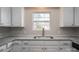 Bright kitchen featuring white cabinetry, stainless steel sink and granite countertops at 570 N Rhyne St, Gastonia, NC 28054