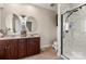 Bathroom featuring double vanity with dark wood cabinets and walk-in shower with marble-like walls at 6808 Austin Grove Church Rd, Marshville, NC 28103