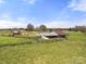Wide view of multiple buildings and large pastures enclosed by fencing at 6808 Austin Grove Church Rd, Marshville, NC 28103