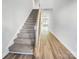 Inviting entryway featuring wood-look floors, a carpeted staircase, and neutral paint at 7120 Saltpeter St, Charlotte, NC 28215