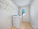 Practical laundry room with washer, dryer, shelving, and tiled floors at 7120 Saltpeter St, Charlotte, NC 28215