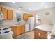 Bright kitchen features wood cabinets, white appliances, tile flooring and natural light from two windows at 7361 Sun Dance Dr, Fort Mill, SC 29707