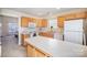 Well-lit kitchen boasts an island, white appliances, ample counter space, and wood cabinets at 7361 Sun Dance Dr, Fort Mill, SC 29707