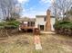 Backyard featuring a wooden deck, brick chimney, patio, and mature landscaping at 755 Ottawa Dr, Rock Hill, SC 29732