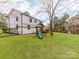 Spacious backyard featuring a playset and swing set, surrounded by lush greenery and mature trees at 7801 Snowden Ln, Charlotte, NC 28270