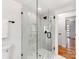 Modern bathroom with a glass shower enclosure featuring elegant tiling, black hardware, and a light fixture at 7801 Snowden Ln, Charlotte, NC 28270