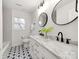 Modern bathroom with double vanity, marble countertop, stylish mirrors and black accents at 7801 Snowden Ln, Charlotte, NC 28270