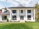 Stunning white brick two-story home with large pillars, black trim, covered entry, and expansive front lawn at 7801 Snowden Ln, Charlotte, NC 28270