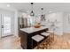 Modern white kitchen featuring a black island with bar stool seating and stainless steel appliances at 7801 Snowden Ln, Charlotte, NC 28270