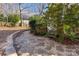 Landscaped backyard featuring a stone pathway and lush greenery with a small wooden deck at 7806 Spanish Oaks Dr, Waxhaw, NC 28173