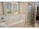 Bright bathroom featuring a soaking tub, a separate shower, and a window with natural light at 7806 Spanish Oaks Dr, Waxhaw, NC 28173