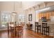 Bright dining area with hardwood floors, connecting to a breakfast bar and kitchen at 7806 Spanish Oaks Dr, Waxhaw, NC 28173