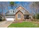 Charming home showcasing a stone and shingle facade, complemented by a manicured lawn and attached two-car garage at 7806 Spanish Oaks Dr, Waxhaw, NC 28173