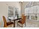 Bright dining area featuring large windows, tile flooring, and space for a four-chair table at 8402 Albury Walk Ln, Charlotte, NC 28277