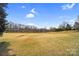 A large open field with scattered trees, showing the spacious natural surroundings at 8501 Golf Ridge Dr, Charlotte, NC 28277