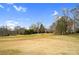 A sprawling green field with mature trees and a distant pond under a sunny sky at 8501 Golf Ridge Dr, Charlotte, NC 28277