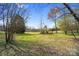 An open field with scattered trees, showing the property's natural landscape at 8501 Golf Ridge Dr, Charlotte, NC 28277