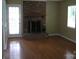 Living room featuring hardwood floors, a brick fireplace, and natural light at 8501 Golf Ridge Dr, Charlotte, NC 28277