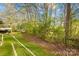 Secluded backyard with a swing and artificial turf, surrounded by mature trees and foliage at 9136 Ladson Rd, Indian Land, SC 29707