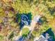 Aerial view of a home with a circular driveway surrounded by lush trees and a well-maintained yard at 10032 Hunters Trace Dr, Concord, NC 28027