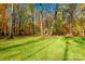 Expansive green backyard with mature trees and a charming garden gazebo in a serene setting at 10032 Hunters Trace Dr, Concord, NC 28027