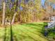 Lush green backyard surrounded by trees, featuring a small garden gazebo and a camper at 10032 Hunters Trace Dr, Concord, NC 28027