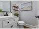 Powder room with a white vanity, decorative mirror, and floral wallpaper at 10032 Hunters Trace Dr, Concord, NC 28027