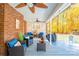 Covered patio with brick accent wall, comfortable seating, ceiling fans, and autumn decor at 10032 Hunters Trace Dr, Concord, NC 28027