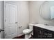 A cozy bathroom features a modern vanity with round mirror and a toilet for convenience at 11203 Chapeclane Rd, Charlotte, NC 28278