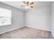 Neutral bedroom featuring plush carpet, natural light, and overhead fan at 11203 Chapeclane Rd, Charlotte, NC 28278