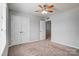 A carpeted bedroom has a ceiling fan, a double door closet and neutral walls at 11203 Chapeclane Rd, Charlotte, NC 28278