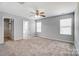 Spacious bedroom with neutral walls, carpeted floors, ceiling fan, and natural light from two windows at 11203 Chapeclane Rd, Charlotte, NC 28278