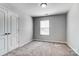 Neutral bedroom featuring plush carpet, a window, and a closet with bi-fold doors at 11203 Chapeclane Rd, Charlotte, NC 28278