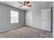 Carpeted bedroom with ceiling fan, window, and double door closet at 11203 Chapeclane Rd, Charlotte, NC 28278