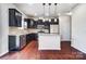Modern kitchen features dark wood cabinets, stainless steel appliances, granite countertops, and a central island at 11203 Chapeclane Rd, Charlotte, NC 28278