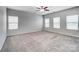 Spacious carpeted living room flooded with natural light from multiple windows and a ceiling fan at 11203 Chapeclane Rd, Charlotte, NC 28278