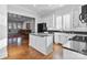 Kitchen with white cabinets, a black refrigerator, and hardwood floors at 1131 S Kings Dr, Charlotte, NC 28207