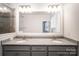 Bathroom with dual sinks, granite counters, and large mirror over the gray vanity at 11679 Red Rust Ln, Charlotte, NC 28277