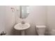 Clean half bathroom featuring a pedestal sink, oval mirror, and toilet at 11679 Red Rust Ln, Charlotte, NC 28277