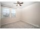 This carpeted bedroom features natural light, a ceiling fan, and a window at 11679 Red Rust Ln, Charlotte, NC 28277