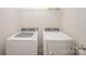 Bright laundry room with modern white washer and dryer and wire shelving above at 11679 Red Rust Ln, Charlotte, NC 28277
