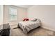 Neutral bedroom with carpet flooring, large window with blinds and a red chair with teddy bear at 120 Hornbeam Ln, Mooresville, NC 28117