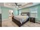 A bright main bedroom with a king bed, ceiling fan, neutral carpet, and en suite bathroom for convenience at 120 Hornbeam Ln, Mooresville, NC 28117