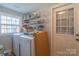 Laundry room with white washer and dryer and shelving for storage at 1216 Center St, Wadesboro, NC 28170
