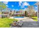 Backyard features a pool with concrete surround, a patio with firepit and seating area at 127 Oxford Dr, Mooresville, NC 28115