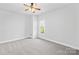 Bright bedroom featuring neutral walls, plush carpet and a ceiling fan with a window overlooking outside at 127 Oxford Dr, Mooresville, NC 28115