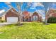 Charming brick home boasts a well-manicured lawn, attached garage, and inviting front porch at 127 Oxford Dr, Mooresville, NC 28115